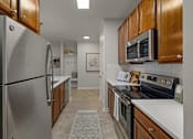 Thumbnail 20 of 43 - a kitchen with stainless steel appliances and wooden cabinets