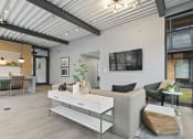 Thumbnail 8 of 28 - a living room with a couch coffee table and a tv on the wall