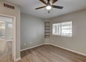 Thumbnail 10 of 37 - A room with a ceiling fan and light fixture, hardwood flooring, and a window with blinds. at The Fletcher Southlands, Colorado, 80015