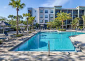 Thumbnail 10 of 69 - a swimming pool with an apartment building in the background