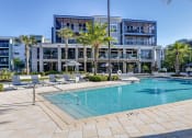 Thumbnail 12 of 69 - a swimming pool in front of a building with palm trees