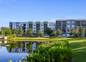 Thumbnail 4 of 69 - a large pond in front of an apartment building