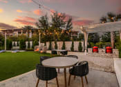 Thumbnail 46 of 69 - a patio with tables and chairs at sunset