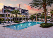Thumbnail 17 of 69 - a swimming pool in front of a building with palm trees