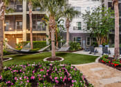 Thumbnail 41 of 69 - a courtyard with hammocks and flowers in an apartment building