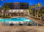 Thumbnail 27 of 69 - a large swimming pool in front of a hotel at night