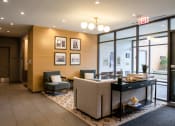 Thumbnail 21 of 28 - a lobby with a reception desk and a couch and a table