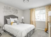 Thumbnail 1 of 25 - A bedroom with a bed, two lamps, and a chair.