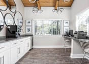 Thumbnail 3 of 25 - A kitchen with white cabinets and a wooden ceiling.