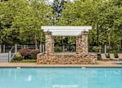 Thumbnail 5 of 25 - A pool with a stone pillar and a white roof.