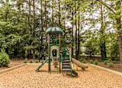 Thumbnail 11 of 25 - A playground with a green slide and a yellow slide.