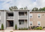 Thumbnail 24 of 25 - A modern two-story apartment building with a garage on the first floor.