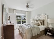 Thumbnail 34 of 39 - A bedroom with a large bed and a ceiling fan.