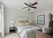 Thumbnail 35 of 39 - A bedroom with a large bed and a ceiling fan.