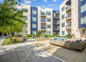 Thumbnail 40 of 51 - a patio with couches and a fire pit in front of an apartment building at Indigo 301 Apartments, Pennsylvania, 19406 at Indigo 301 Apartments, Pennsylvania, 19406