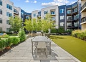 Thumbnail 33 of 51 - a patio with a table and chairs in front of an apartment building at Indigo 301 Apartments, Pennsylvania, 19406