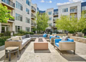 Thumbnail 39 of 51 - a seating area with couches and a fire pit in front of an apartment building at Indigo 301 Apartments, Pennsylvania, 19406