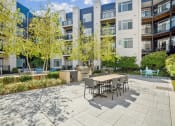 Thumbnail 32 of 51 - a patio with a table and chairs in front of an apartment building at Indigo 301 Apartments, Pennsylvania, 19406