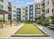 Thumbnail 26 of 51 - a grassy area with benches and tables in front of an apartment building at Indigo 301 Apartments, Pennsylvania, 19406