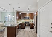 Thumbnail 39 of 39 - A modern kitchen with dark wood cabinets and stainless steel appliances.