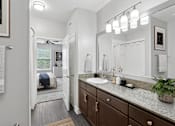 Thumbnail 28 of 39 - A bathroom with a white sink and brown cabinets.
