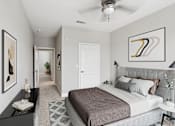 Thumbnail 22 of 39 - A bedroom with a large bed and a ceiling fan.