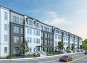 Thumbnail 1 of 10 - A red car is parked on the street in front of a row of apartment buildings.