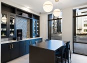 Thumbnail 33 of 65 - a kitchen with blue cabinets and a long island with blue chairs at Stonehill at West Orange, West Orange, 07052