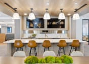 Thumbnail 28 of 65 - a modern kitchen with a bar and stools in front of a table with chairs at Stonehill at West Orange, West Orange, NJ, 07052