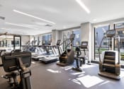 Thumbnail 44 of 65 - a gym with cardio equipment and windows in a building at Stonehill at West Orange, West Orange, NJ