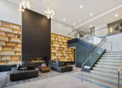 Thumbnail 21 of 65 - a lobby with couches and a staircase and a fireplace at Stonehill at West Orange, West Orange, NJ, 07052