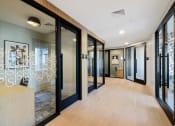 Thumbnail 29 of 65 - a long hallway with glass doors and a reception desk at Stonehill at West Orange, West Orange, New Jersey