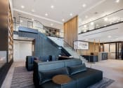 Thumbnail 22 of 65 - a large lobby with couches and a staircase at Stonehill at West Orange, West Orange, NJ
