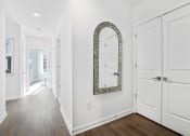 Thumbnail 14 of 65 - a hallway with white doors and a mirror on the wall at Stonehill at West Orange, West Orange