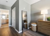 Thumbnail 11 of 65 - a hallway with a mirror and a dresser and a bathroom at Stonehill at West Orange, West Orange, NJ