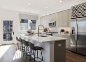 Thumbnail 2 of 65 - a kitchen with a large island and stainless steel appliances at Stonehill at West Orange, West Orange