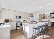 Thumbnail 3 of 65 - a large white kitchen with a large island and bar stools at Stonehill at West Orange, West Orange, NJ, 07052