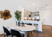 Thumbnail 16 of 65 - an open kitchen and dining area with a marble table and black chairs at Stonehill at West Orange, West Orange, New Jersey