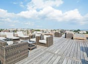 Thumbnail 9 of 17 - a rooftop deck with lounge chairs and a fire pit at 1841 Columbia Road Apartments, Washington, Washington DC