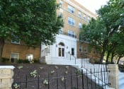 Thumbnail 25 of 27 - a large brick building with stairs and trees in front of it