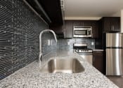 Thumbnail 1 of 13 - a kitchen with a sink a stove and a refrigerator