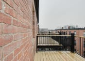 Thumbnail 4 of 13 - a brick wall with a wooden deck in front of it