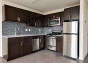 Thumbnail 7 of 13 - a kitchen with wooden cabinets and stainless steel appliances