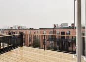 Thumbnail 13 of 13 - a balcony with a wooden railing and a brick building in the background