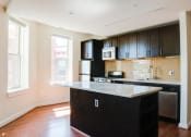 Thumbnail 3 of 25 - a kitchen with black cabinets and a white counter top