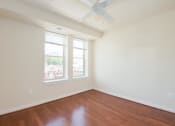 Thumbnail 5 of 25 - an empty room with two windows and a ceiling fan