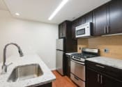 Thumbnail 8 of 25 - a kitchen with a sink stove refrigerator and microwave