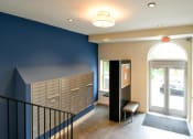 Thumbnail 2 of 27 - a hallway with blue walls and a staircase with a chair and lockers