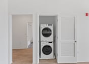 Thumbnail 5 of 66 - A white door is open to reveal a stacked washer and dryer.
