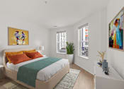 Thumbnail 33 of 66 - A bedroom with a bed, nightstand, and two paintings on the wall.